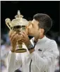  ?? TIM IRELAND - AP ?? Novak Djokovic kisses the trophy after defeating Roger Federer in the men’s singles final match of Wimbledon in London, Sunday.