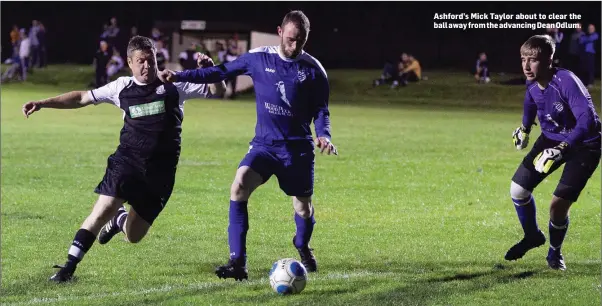  ??  ?? Ashford’s Mick Taylor about to clear the ball away from the advancing Dean Odlum.