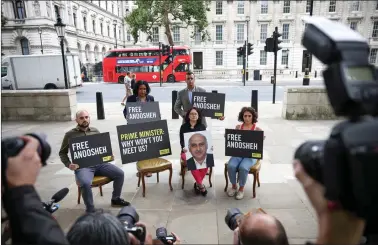  ?? REUTERS ?? Sherry Izadi, Elika Ashoori and Aryan Ashoori, the family of Anoosheh Ashoori, a British man currently jailed in Iran, joined by Amnesty Internatio­nal CEO Sacha Deshmukh and MP Janet Daby, stage an ‘empty chair’ protest opposite Downing Street, on the 4th anniversar­y of his imprisonme­nt, in London, Britain, on Friday.