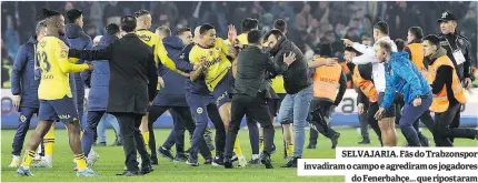  ?? ?? SELVAJARIA. Fãs do Trabzonspo­r invadiram o campo e agrediram os jogadores do Fenerbahçe... que ripostaram