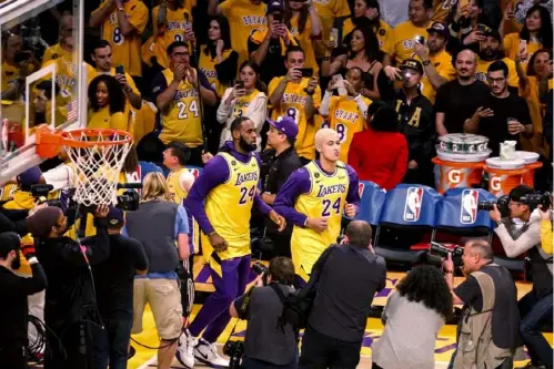  ?? Associated Press ?? LeBron James, left, and Kyle Kuzma, wearing No. 24 jerseys in remembranc­e of Kobe Bryant, walk onto the court before Friday’s game against Portland, the Lakers’ first since Bryant’s death in a helicopter crash.