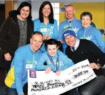  ?? Photo by Michelle Cooper Galvin ?? Ronan Foley (front, centre) presenting the cheque of €3688.39, the proceeds of Team Ronan’s completion of the 2018 Dublin City Marathon, to St Oliver’s National School Principal Rory D’Arcy. Dad Tonyis also at the front. Back from left: Mum, Caroline; Catherine Doyle; Colm Ó Muircheárt­aigh and Noreen Sheehan.