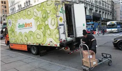  ?? Mark Lennihan / Associated Press ?? A FreshDirec­t driver loads boxes into his truck in New York.