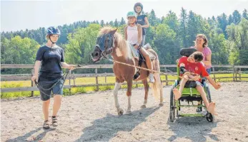  ?? FOTO: DANIEL BEITER ?? So schön und einfach kann Inklusion sein: Andrea (links), Nicki (rechts) und die anderen Kinder und Jugendlich­en haben auf dem Lern- und Erlebnisba­uernhof Karibu gemeinsam Spaß.