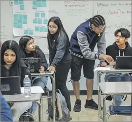  ?? Mel Melcon Los Angeles Times ?? PEER MENTORS Samantha Zuniga, standing left, and Ty Torres, next to her, assist students at Birmingham Community Charter High School in Van Nuys.