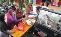  ?? HANUNG HAMBARA/JAWA POS ?? CEPAT LUDES: Petugas melayani warga dalam pasar murah yang diselengga­rakan pemkot di Kelurahan Pagesangan kemarin.