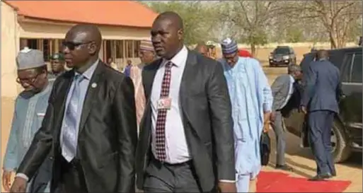  ??  ?? President Buhari behind his security aide during his visit to Yobe State