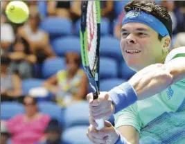  ?? AP PHOTO ?? Milos Raonic makes a backhand return to Germany’s Dustin Brown during their first round match at the Australian Open tennis championsh­ips in Melbourne yesterday.