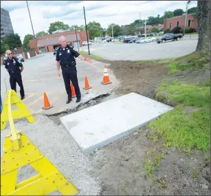  ?? Ernest A. Brown photo/The Call ?? Police Chief Thomas Oates points out where the new cantilever­ed-gate is being installed as an entrancewa­y for Woonsocket police vehicles entering the parking lot at police headquarte­rs during an announceme­nt about the new high-security fence being installed around the perimeter of the facility last week. An exit gate is also being installed on the Clinton Street side of the facility.