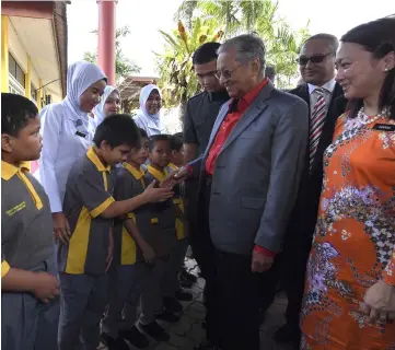  ?? — Bernama photo ?? Dr Mahathir shakes hands with a disabled child at the gathering with educators.