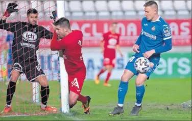  ??  ?? Raúl Carnero, del Getafe, observa cómo Víctor frena contra el poste en presencia del meta Adrián.