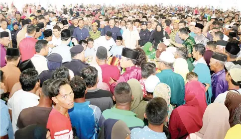  ?? - Bernama photo ?? CM Datuk Seri Mohd Shafie Apdal (seated, middle) and wife Datin Seri Shuryani Shuaib swarmed by visitors at the Aidilfitri open house held at the town field in Semporna.