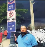  ?? Scoops & Sprinkles / Contribute­d photo ?? Co-owner of Rocky Hill-based ice cream shop Scoops & Sprinkles Shane Aforismo poses next to a prop street sign for the Hallmark movie, “Christmas in Harlem.” Aforismo’s ice cream cart was used as a prop in the film, and he and his wife, Kim, got to serve as the ice cream cart vendors in the film.