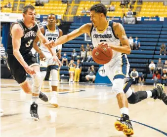  ?? STAFF PHOTO BY ROBIN RUDD ?? UTC’s Nat Dixon dribbles to the basket while Wofford’s Fletcher Magree defends in their game at McKenzie Arena last Saturday.