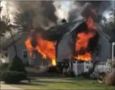  ?? FACEBOOK PHOTO ?? Flames roar through house in Trainer Thursday morning. A police officer rescued one person who was trapped inside the home.