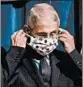  ?? THE NEW YORK TIMES ?? Dr. Anthony Fauci puts on a face mask during a coronaviru­s briefing in June.