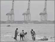  ?? AP/KAMRAN JEBREILI ?? Asian workers fish Saturday in the floodwater after Merkunu struck in Salalah, Oman. Cyclone