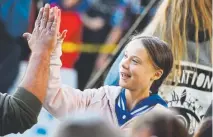  ?? RJ Sangosti, The Denver Post ?? Swedish teenager Greta Thunberg high-fives a fellow climate activist Friday after she spoke during a rally at Civic Center’s Greek Amphitheat­re in Denver.