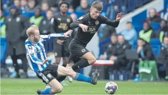  ?? ?? Posh midfielder Harrison Burrows is tackled by Sheffield Wednesday star Barry Bannon.