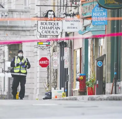  ?? MATHIEU BELANGER / REUTERS ?? A police officer secures one of the areas where multiple people were stabbed Saturday night in Quebec City.