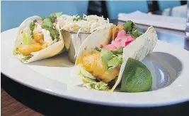  ??  ?? The delicious fish tacos consist of tortillas filled with fried cod, pickled onions, coriander, lettuce and a creamy sauce.