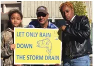  ?? ?? Watson Chapel Junior High School seventh grader Xandria Johnson (from left), Jefferson County Cooperativ­e Extension Service Urban Stormwater agent Kevin Harris and Watson Chapel High School senior Laila McClain promote the 2021 Storm Drain Mural Project. The two girls were selected to complete storm drains as part of the project. (Special to The Commercial)