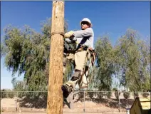  ?? Buy this photo at YumaSun.com PHOTO BY MARA KNAUB/YUMA SUN ?? TRAVIS DUCHARME, A JOURNEYMAN LINEMAN with Arizona Public Service, demonstrat­es pole-climbing during a Wednesday morning monsoon kickoff event held in the APS yard. Monsoon season officially starts today.