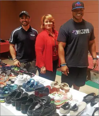  ?? BILL RETTEW JR. – DIGITAL FIRST MEDIA ?? Josh Pierlott, of Anytime Fitness, Salvation Army Captain Maria Corraliza and Lou Samba, of Anytime Fitness, pose with donated shoes.