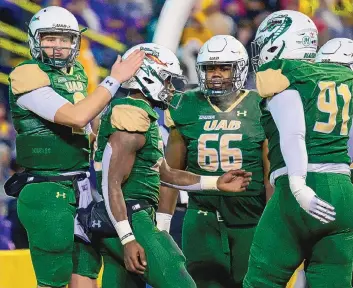  ?? MATTHEW HINTON/ASSOCIATED PRESS ?? Former UAB quarterbac­k Dylan Hopkins, left, celebrates a touchdown with teammate DeWayne McBride, second from left, during a Nov. 19, 2022, game against LSU in Baton Rouge, La. Hopkins is now a Lobo.