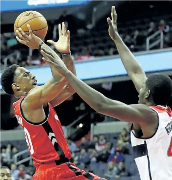  ??  ?? Toronto Raptors’ forward DeMar DeRozan puts up a shot in front of Andrew Nicholson of the Washington Wizards in the first half of pre-season basketball at Verizon Center in Washington.