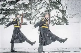  ?? Mladen Antonov AFP/Getty Images ?? RUSSIAN honor guards march at the Tomb of the Unknown Soldier outside the Kremlin. Snow day is a novel concept to Muscovites, long used to winter storms.