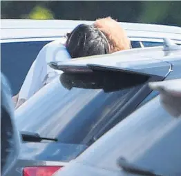  ??  ?? Harry goes in for a smooch with his girlfriend Meghan before he hugs her in the car park at Coworth Park Polo Club near Ascot yesterday