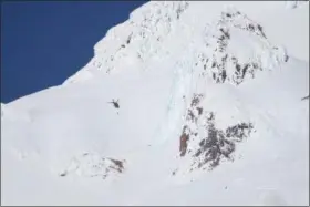  ?? DAVE KILLEN — THE OREGONIAN VIA AP ?? A rescue helicopter and ground teams attempt to reach stranded climbers on Mount Hood in Oregon on Tuesday. Rescuers scrambled up Oregon’s tallest peak Tuesday after a climber fell several hundred feet and several others were stranded, authoritie­s said.