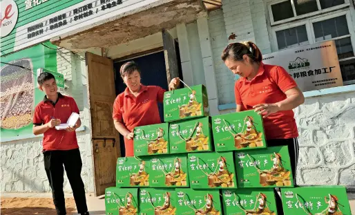  ??  ?? Le 27 août 2018, des employés de l’usine de transforma­tion agroalimen­taire de Zhongbang du village de Xiguo ( province du Hebei ) s’apprêtent à livrer des produits céréaliers.