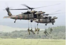  ?? — AFP ?? This file photo taken on August 24, 2017 shows Japan Ground Self-Defence Force troops abseiling from helicopter­s during an annual live-fire exercise at the Higashi-Fuji firing range in Gotemba, at the foot of Mount Fuji in Shizuoka prefecture.