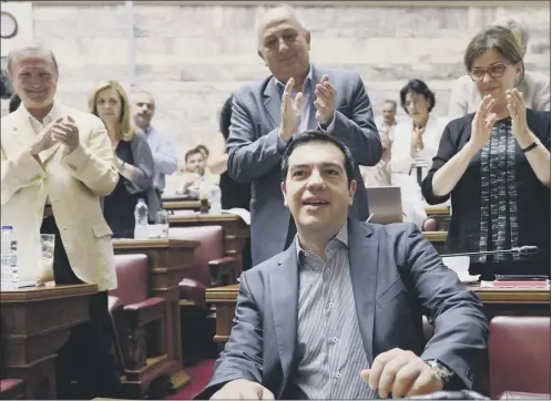  ?? Picture: Afp/getty ?? PM Alexis Tsipras is applauded by members of his parliament­ary group of MPS before addressing them yesterday