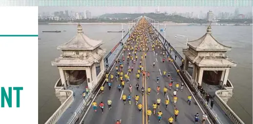  ?? AFP PIC ?? Participan­ts crossing the Yangtze River Bridge as they compete in the Wuhan Marathon last year. Cheating by Chinese marathon runners has become so rampant that there are warnings it is harming the country’s reputation.