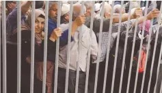  ?? (Raneen Sawafta/Reuters) ?? PALESTINIA­N WORKERS wait at checkpoint en route to work in Israel.