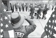  ?? Arkansas Democrat-Gazette/THOMAS METTHE ?? Pallbearer­s with the U.S. Army Honor Guard from Camp Robinson carry the remains of Pvt. Rudolph Johnson past Patriot Guard members holding flags during Johnson’s funeral service Friday at the Arkansas State Veteran’s Cemetery in North Little Rock.