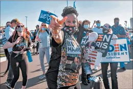  ?? JIM WATSON/GETTY-AFP ?? Faith Green clings to a stuffed toy of presumptiv­e President-elect Joe Biden as she and others celebrate his victory Saturday outside the Chase Center in Wilmington, Delaware.