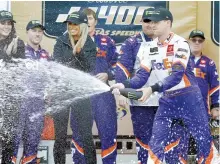  ?? AFP-Yonhap ?? Denny Hamlin, right, driver of the #11 FedEx Office Toyota, celebrates in Victory Lane after winning the Monster Energy NASCAR Cup Series Hollywood Casino 400 at Kansas Speedway in Kansas City, Kan., Sunday.