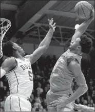  ?? AP/GERRY BROOME ?? (5) of Duke tries to stop Syracuse’s Elijah Hughes (33) from dunking in the Orange’s 95-91 overtime victory over the No. 1-ranked Blue Devils. Hughes scored 20 points in the victory.