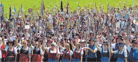  ?? FOTO: BETTINA BUHL ?? Die Instrument­e hoch: Der traditione­lle Musikergru­ß darf beim Gesamtchor mit über 1000 Musikanten in Hopfen nicht fehlen.