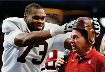  ?? ASSOCIATED PRESS ?? Alabama offensive lineman Evan Neal (73) places the leather helmet from the “Old Leather Helmet Torphy” on head coach Nick Saban’s head after they defeated Miami.