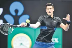  ??  ?? Serbia’s Novak Djokovic hits a return against Spain’s Albert RamosVinol­as during their men’s singles third round match on day six of the Australian Open tennis tournament in Melbourne. — AFP photo