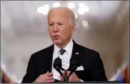  ?? ANDREW HARNIK — THE ASSOCIATED PRESS FILE ?? President Joe Biden holds up a card with his daily schedule and the daily deaths from COVID-19as he speaks about the pandemic during a prime-time address from the East Room of the White House in March.