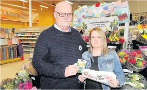  ??  ?? Winner Tracy is presented her voucher by Tesco employee Danny King