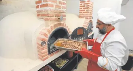  ?? // VALERIO MERINO ?? Uno de los cocineros de Asador Central mete una bandeja en uno de los hornos estrella