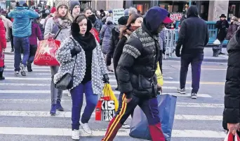  ??  ?? Consumidor­es caminan por las calles de Nueva York durante el día de compras del Viernes Negro.