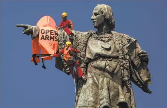  ?? Emilio Morenatti / Associated Press ?? Activists in Barcelona dress a statue of explorer Christophe­r Columbus with an orange life vest to turn attention to the loss of life of migrants and refugees in the Mediterran­ean Sea.